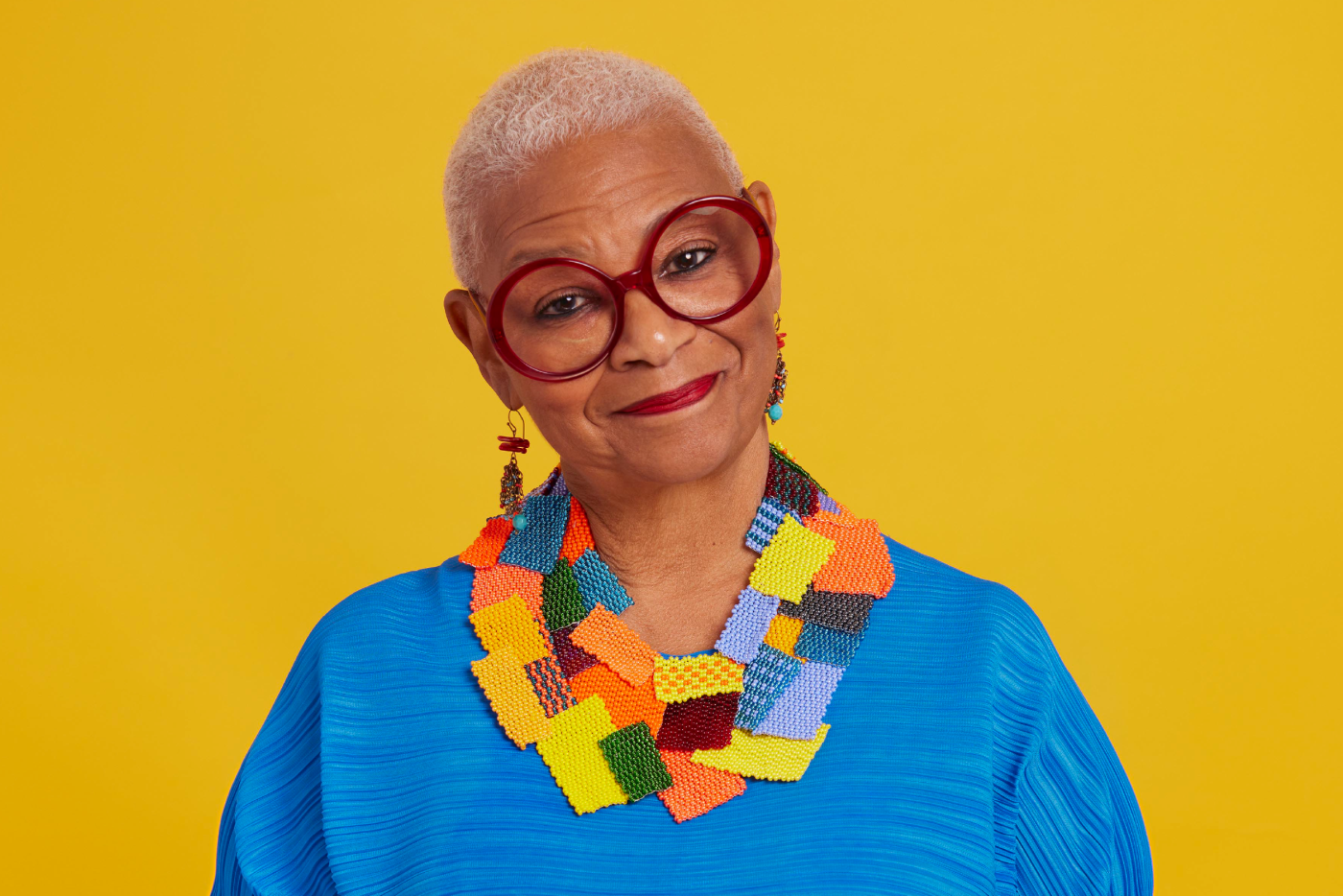 NC Poet Laureate Jaki Shelton Green pictured on a bright, yellow background