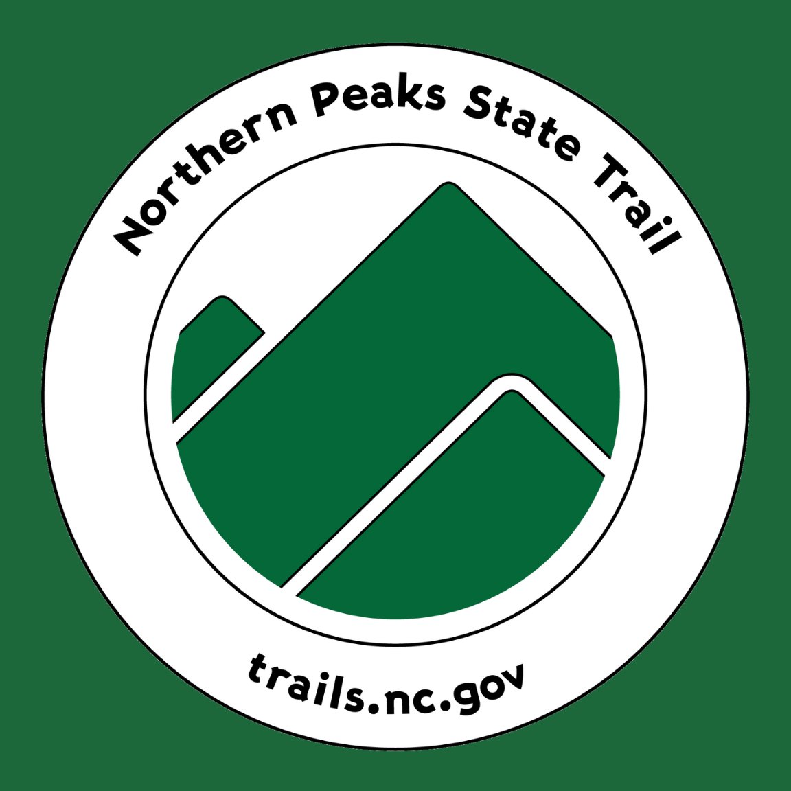 Northern Peaks State Trail blaze with mountains