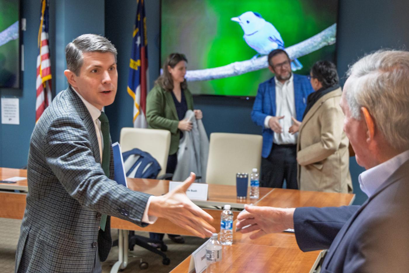 Treasurer Briner shakes hands with SHP board member on the March 17, 2026 SHP board meeting