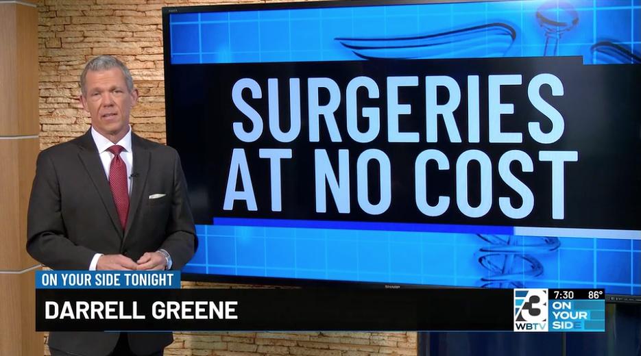 Man Standing in front of tv monitor with the text "Surgeries At No Cost" onscreen