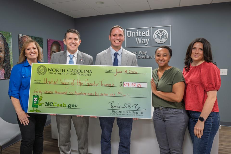Treasurer Brad Briner (left center) presents a check for $47,197.25 to the United Way of the Greater Triangle CEO Jeffery Howell (right center) and other United Way of the Greater Triangle staff.