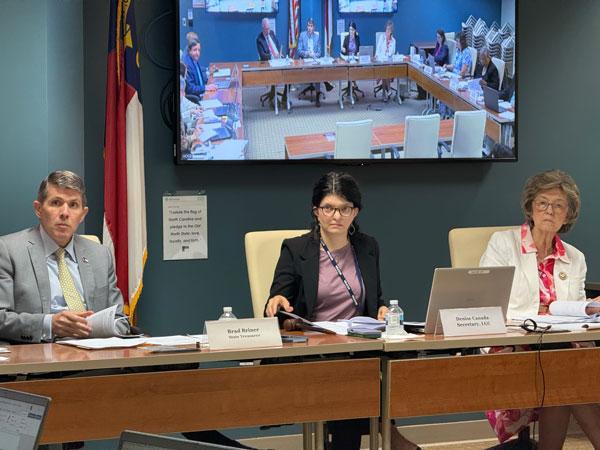 N.C. State Treasurer Brad Briner, State and Local Government Finance Division, Deputy Treasurer Denise Canada and N.C. Secretary of State Elaine Marshall review items at the Tuesday, August 4, 2026, Local Government Commission meeting.