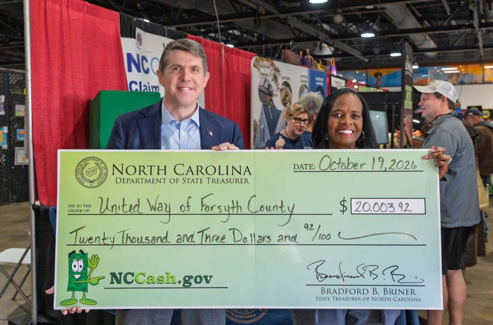 Treasurer Brad Briner returns $20,003.92 to Dr. Antonia Richburg of the United Way of Forsyth County